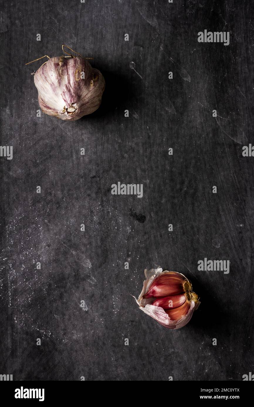 Fresh garlic bulbs and cloves grouped on black background. Flat lay ...