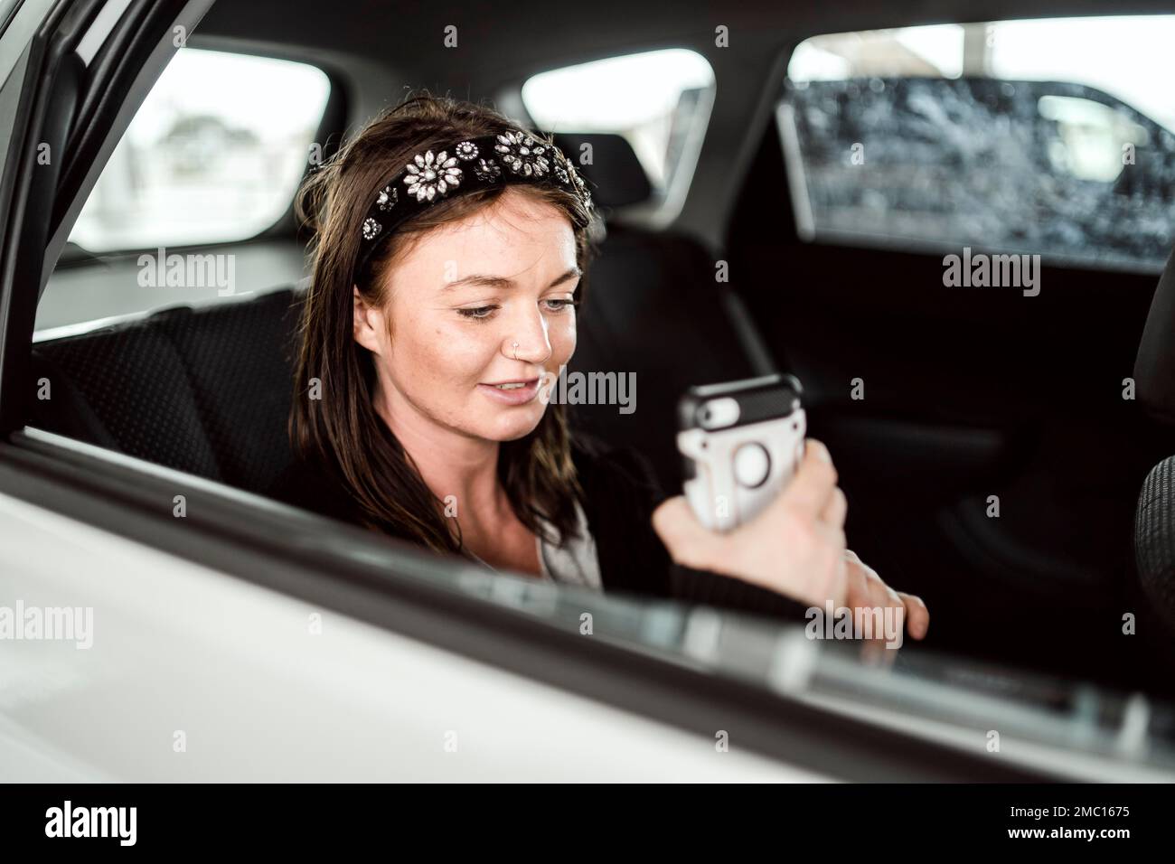 A taxi or Uber passenger talking through the phone on the car back seat Stock Photo