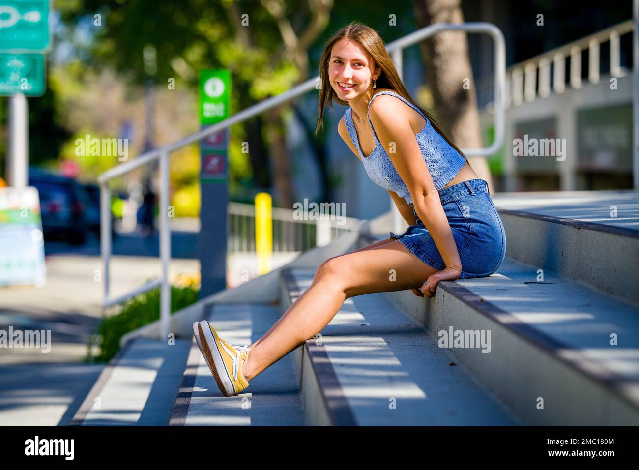 Teenage Girl Sitting on Steps in Front of City Hall Plaza in Downtown Palo Alto Stock Photo