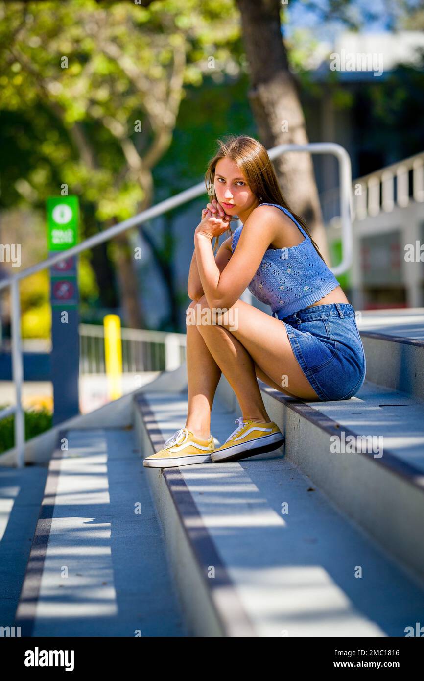 Teenage Girl Sitting on Steps in Front of City Hall Plaza in Downtown Palo Alto Stock Photo