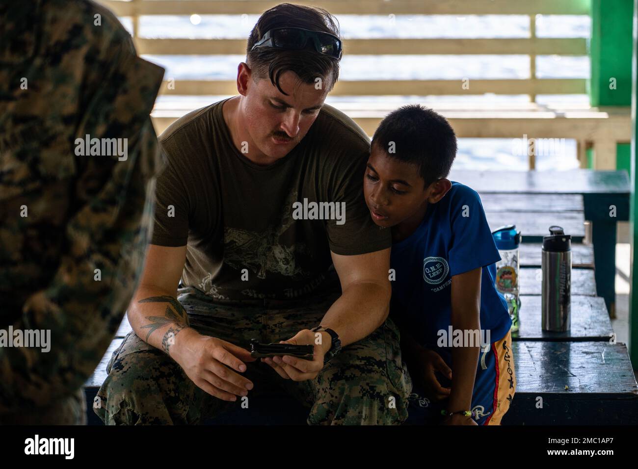 U.S. Navy Hospital Corpsman 2nd Class Aaron Johnson with Task Force Koa Moana 22, I Marine Expeditionary Force, demonstrates the different parts of his multi-tool to a camper participating in the Division of Juvenile Justice’s Omesuub Ngosisechakl Emesmechokl Law Enforcement Explorers Program in Ngeremlengui, Republic of Palau, June 23, 2022. Omesuub Ngosisechakl Emesmechokl in the native language translates to learning, teaching and discipline, traits that are exemplified by the Marines and Sailors strengthening U.S. partnerships through subject matter expert exchanges. Named “Koa Moana,” aft Stock Photo