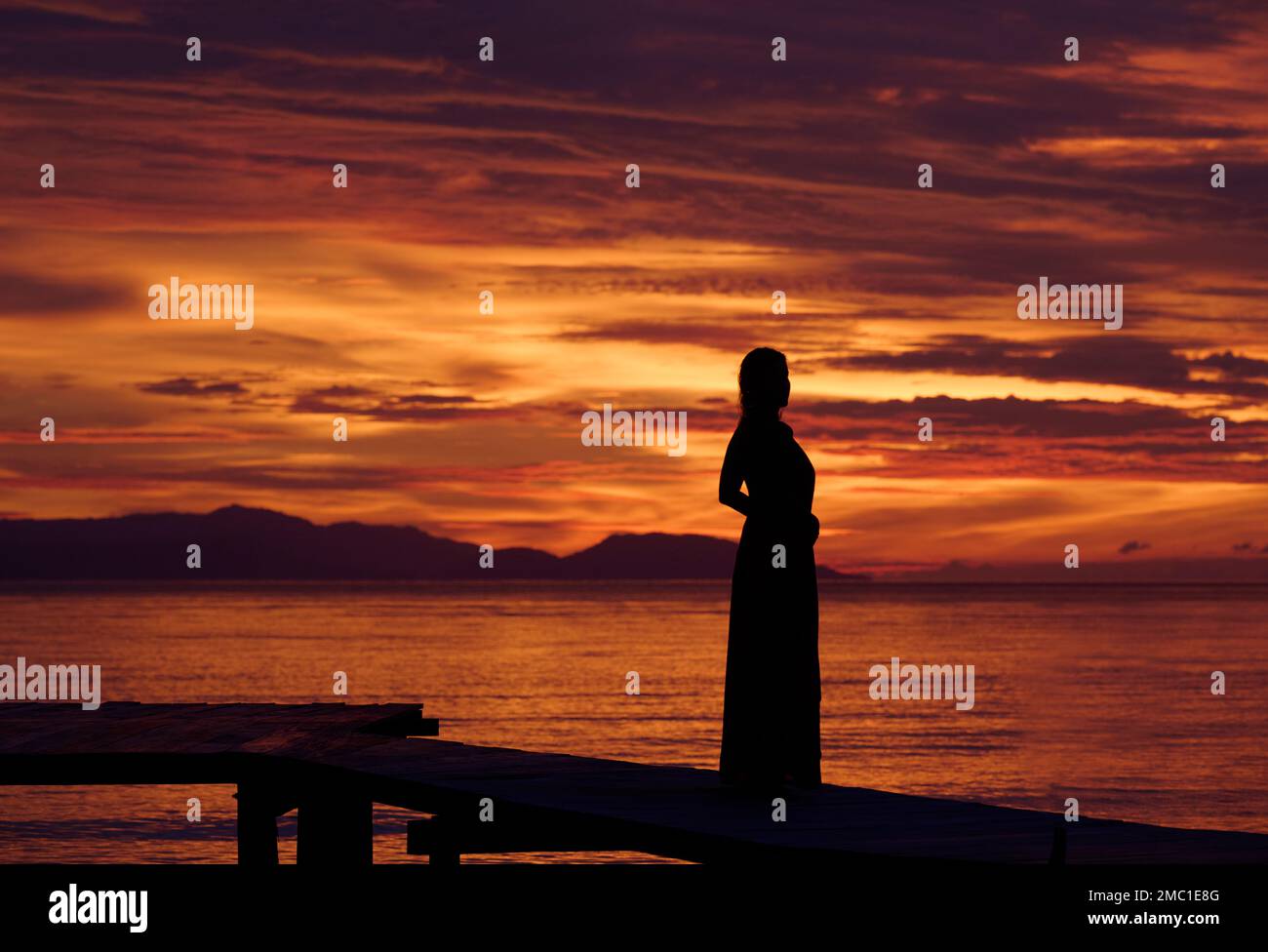 Silhouette of a woman watching the sunset over  Raja Ampat Islands, Indonesia. Stock Photo