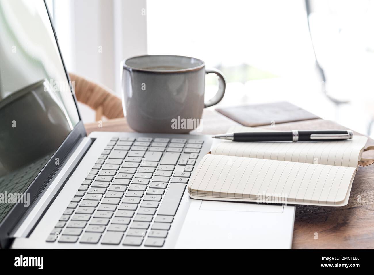 notepad and ballpoint pen on laptop computer, work from home concept Stock Photo