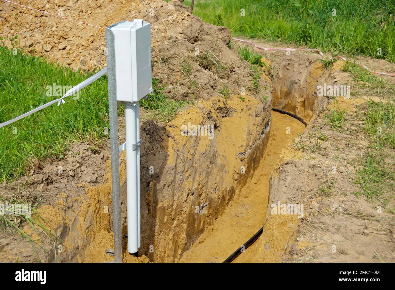 Open cable trench with power cable and house connection box Stock Photo