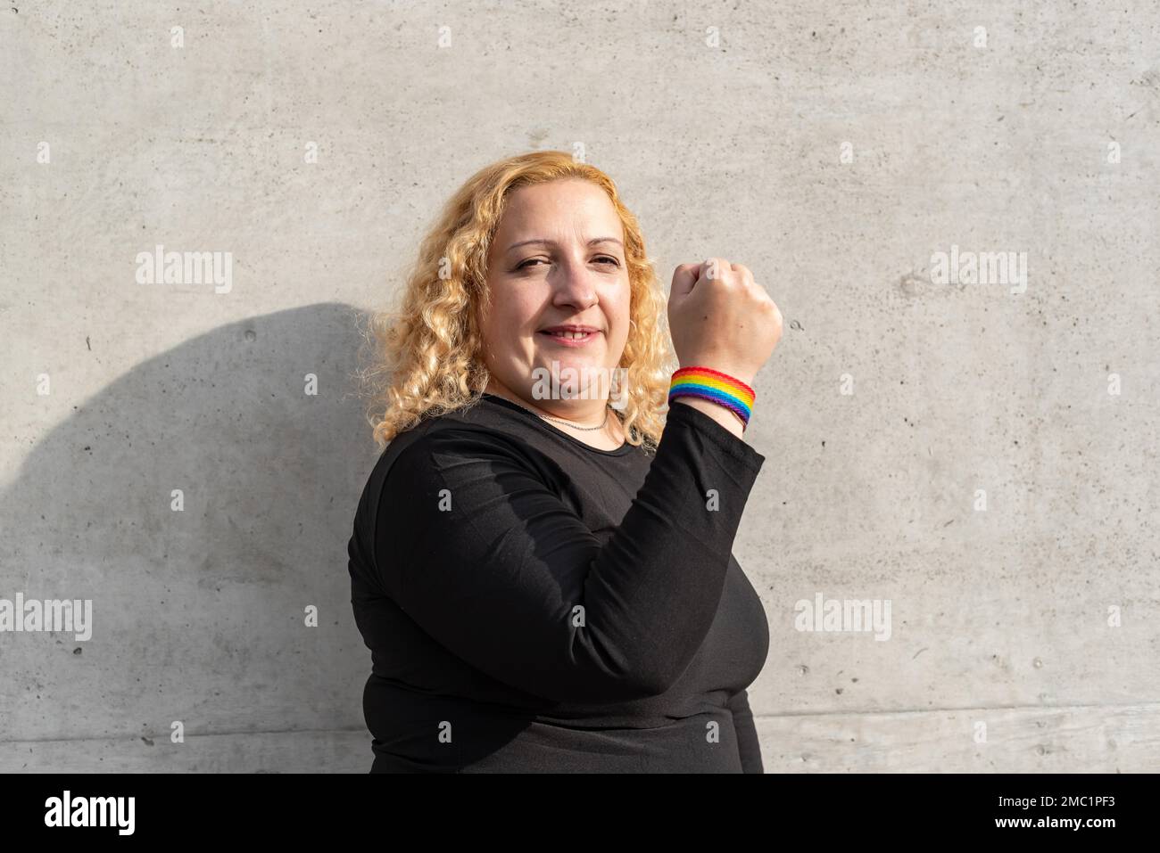 LGBTFrau, die ein LGBTQRegenbogenarmband traegt, Konzept des HomosexuellenStolzMonats