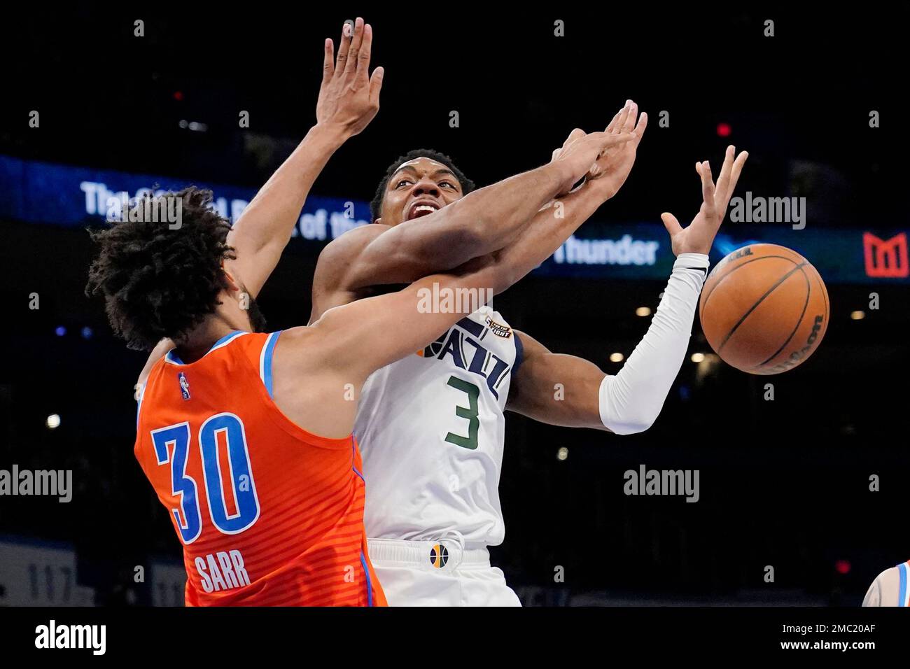 Oklahoma City Thunder center Olivier Sarr, right, dunks over Memphis  Grizzlies forward Brandon Clarke (15) in the first half of an NBA  basketball game Sunday, March 13, 2022, in Oklahoma City. (AP