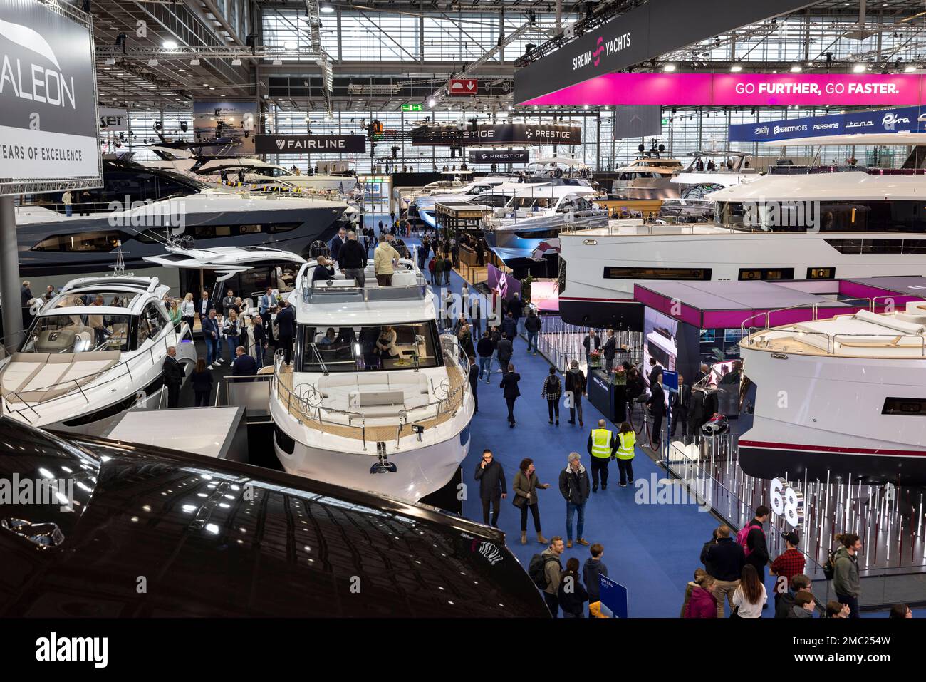 Duesseldorf, Germany. 21st Jan, 2023. Visitors look at expensive yachts in an exhibition hall. After a two-year break from Corona, the boot water sports trade show has opened its doors again. Until January 29, around 1,500 exhibitors from 68 countries will be showing their products and services in 16 halls at the Düsseldorf exhibition center. Credit: Christoph Reichwein/dpa/Alamy Live News Stock Photo
