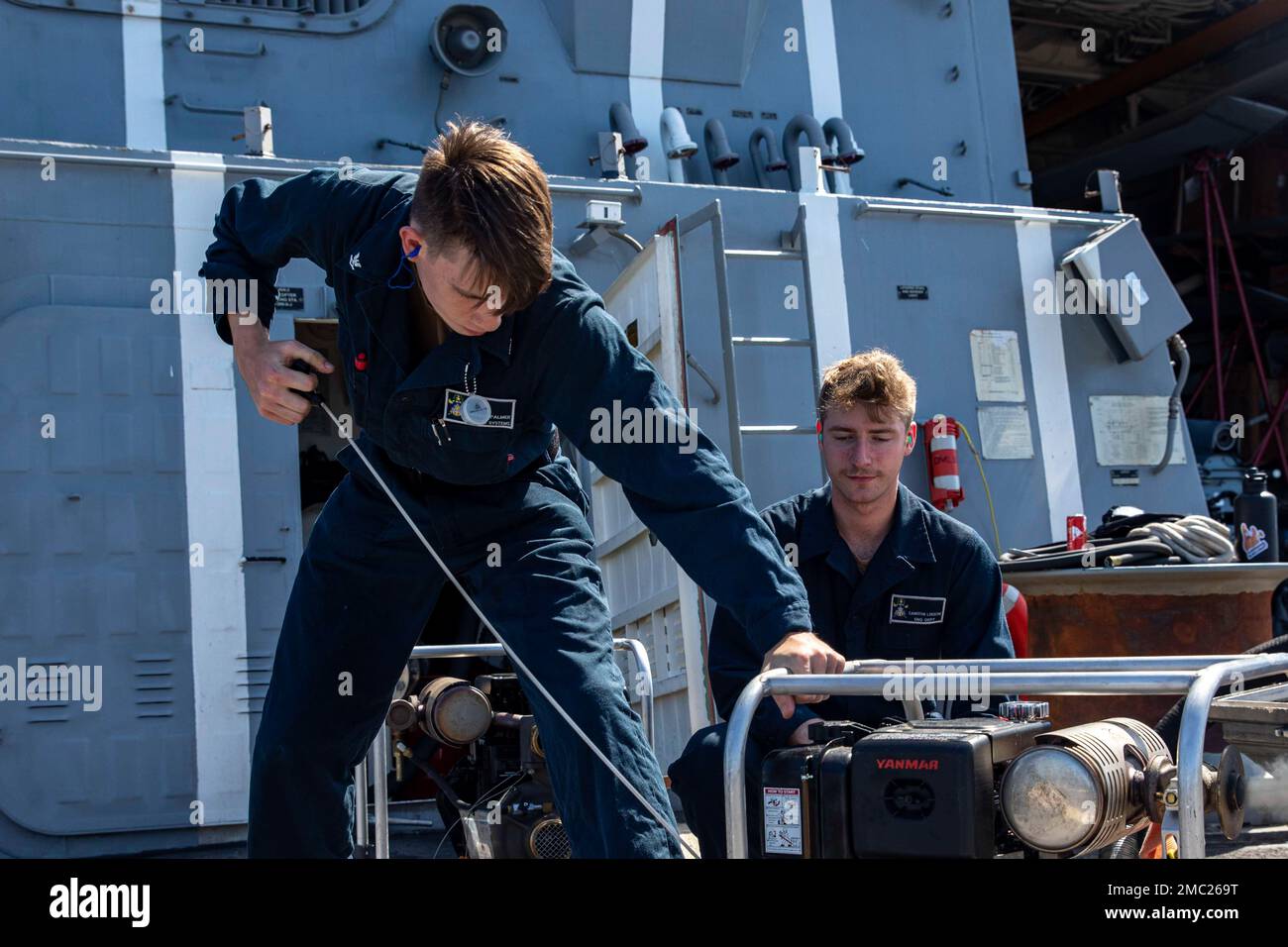 220623-N-UL352-1015 ATLANTIC OCEAN (June 23, 2022) Fireman Cameron Loesche, right, trains Electronics Technician 3rd Class Nathan Palmer, both assigned to the Arleigh Burke-class guided-missile destroyer USS Delbert D. Black (DDG 119), on the use of a portable suction pump, June 23, 2022. The George H.W. Bush Carrier Strike Group (CSG) is underway completing a certification exercise to increase U.S. and allied interoperability and warfighting capability before a future deployment. The George H.W. Bush CSG is an integrated combat weapons system that delivers superior combat capability to deter, Stock Photo