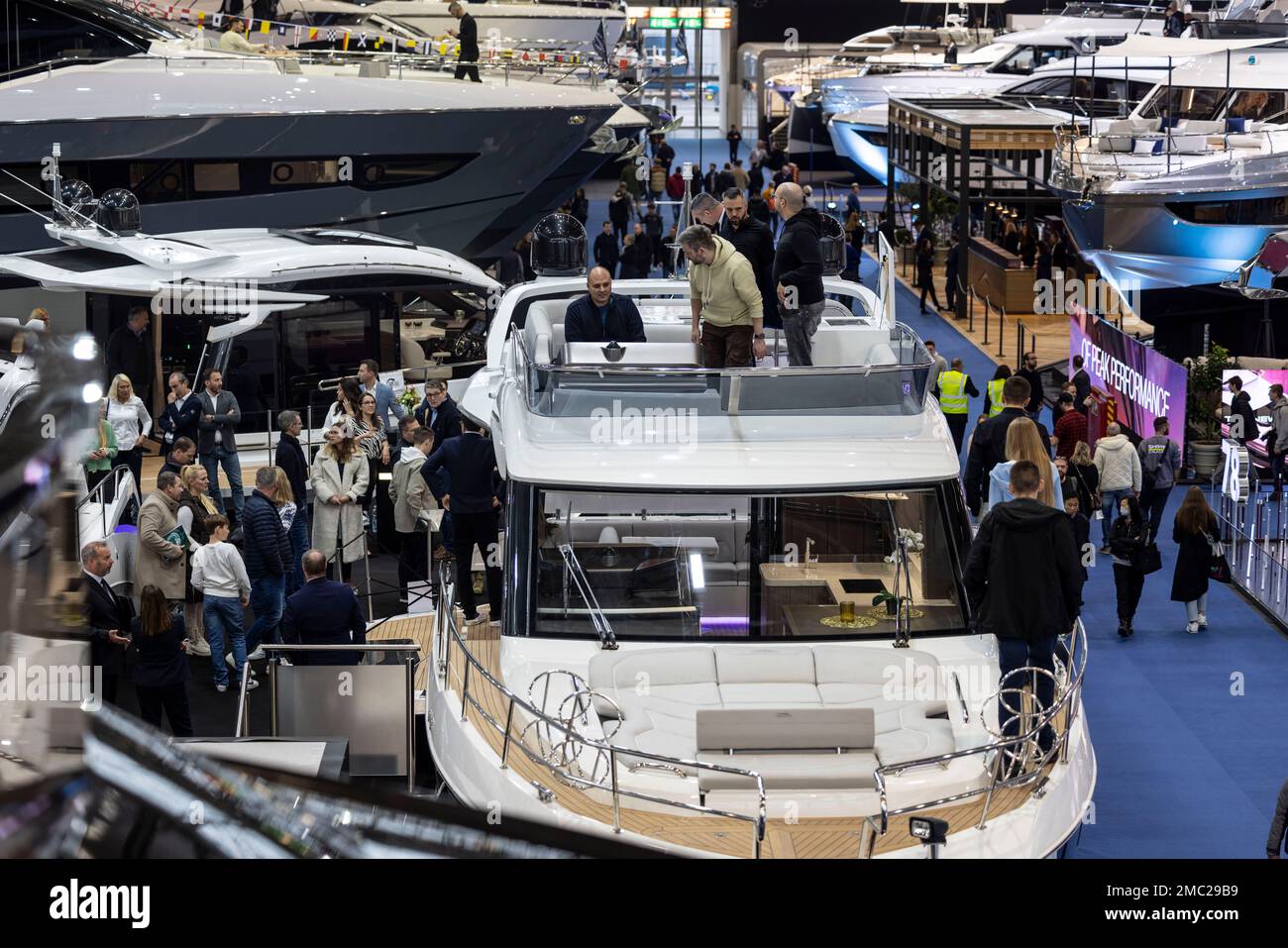 Duesseldorf, Germany. 21st Jan, 2023. Visitors look at a motor yacht in an exhibition hall. After a two-year break from Corona, the boot water sports trade show has opened its doors again. Until January 29, around 1,500 exhibitors from 68 countries will be showing their products and services in 16 halls at the Düsseldorf exhibition center. Credit: Christoph Reichwein/dpa/Alamy Live News Stock Photo