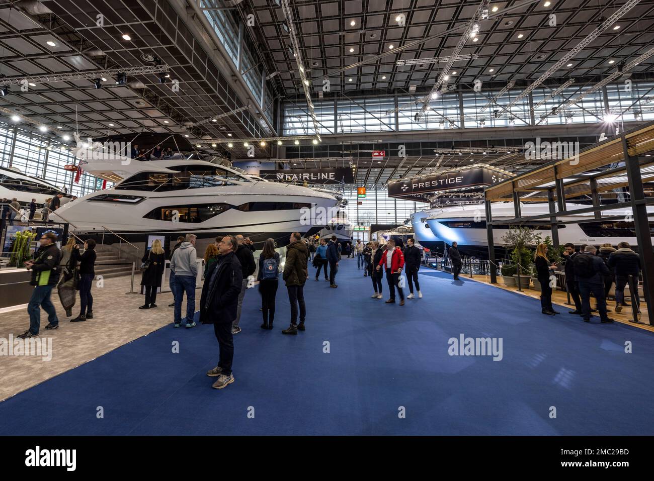 Duesseldorf, Germany. 21st Jan, 2023. Visitors look at expensive yachts in an exhibition hall. After a two-year break from Corona, the boot water sports trade show has opened its doors again. Until January 29, around 1,500 exhibitors from 68 countries will be showing their products and services in 16 halls at the Düsseldorf exhibition center. Credit: Christoph Reichwein/dpa/Alamy Live News Stock Photo