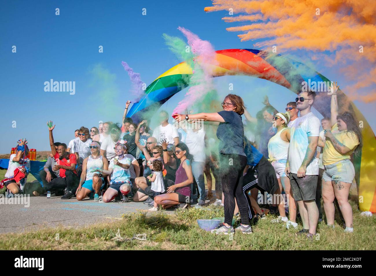 Airmen and families take a group photo after the Pride Month color run ...