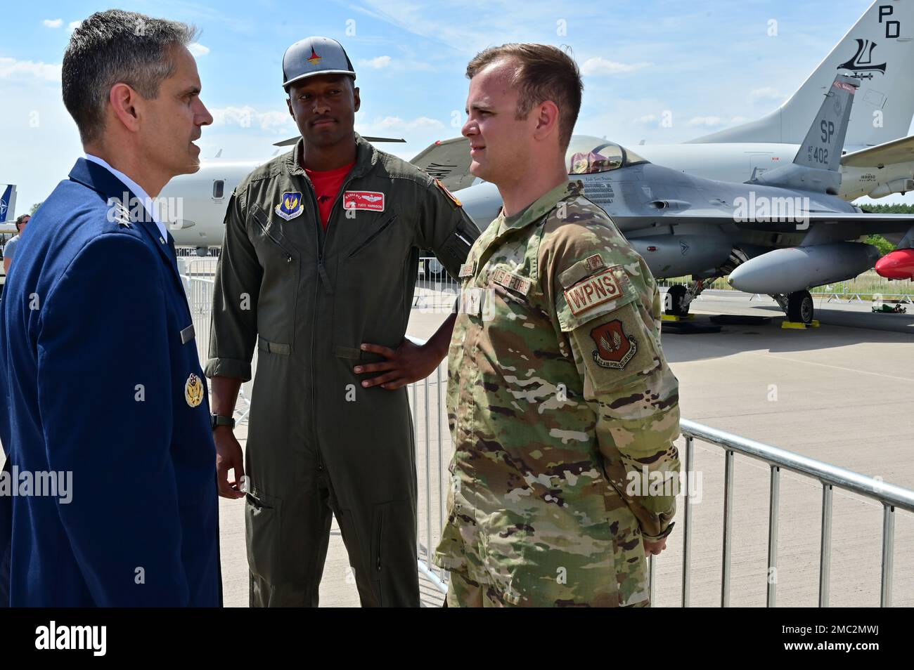 U.S. Air Force Lt. Gen. Steven Basham, U.S. Air Forces in Europe-Air Forces Africa deputy commander, visited with U.S. Air Force Airman 1st Class Jacob Sheppard (right), an F-16 Fighting Falcon Weapons Specialist, and Major Tuco Harrison an F-16 pilot, both assigned to the 52nd Fighter Wing, Spangdahlem Air Base, Germany, and coined Sheppard for outstanding performance during the Innovation and Leadership in Aerospace Tradeshow in Berlin, at the Berlin Expo Center Airport, Germany, June 24, 2022. Basham also coined other Airmen, Soldiers and a Sailor who each specialize in a variety of areas i Stock Photo