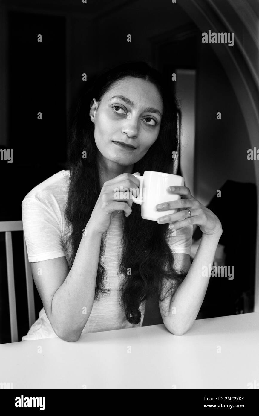 Young woman holding a cup of coffee indoor Stock Photo