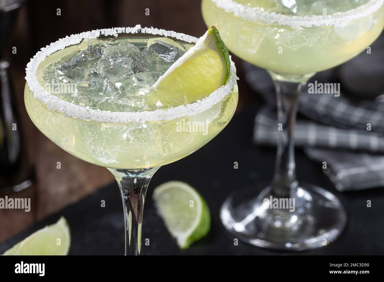 Margarita cocktail with ice, lime and salt rim on a black slate board Stock Photo