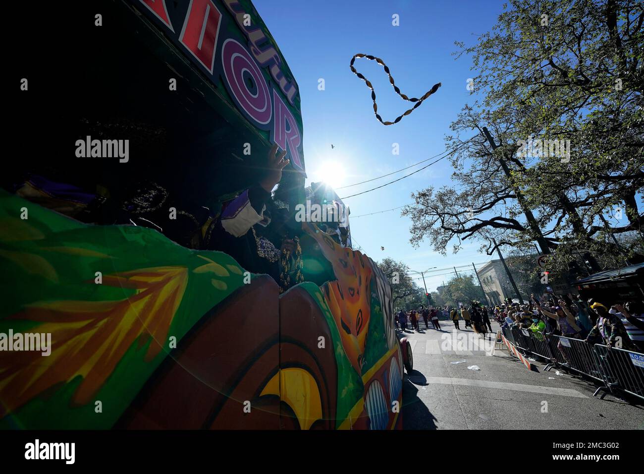 Members of the Krewe of Zulu parade throw beads from a float during