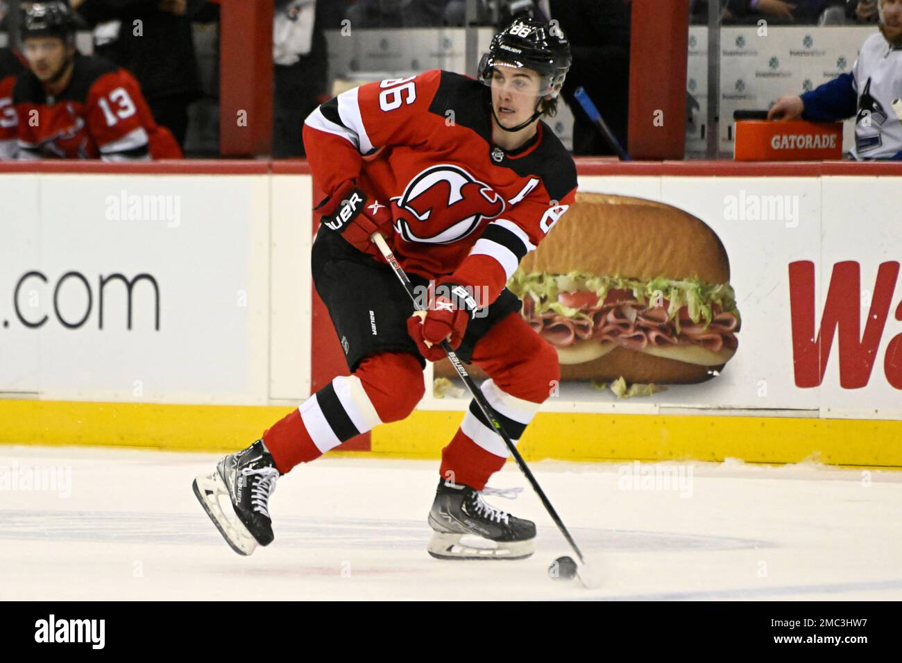 New Jersey Devils center Jack Hughes (86) looks to pass the puck during the  first period of an NHL hockey game against the Vancouver Canucks Monday,  Feb. 28, 2022, in Newark, N.J. (