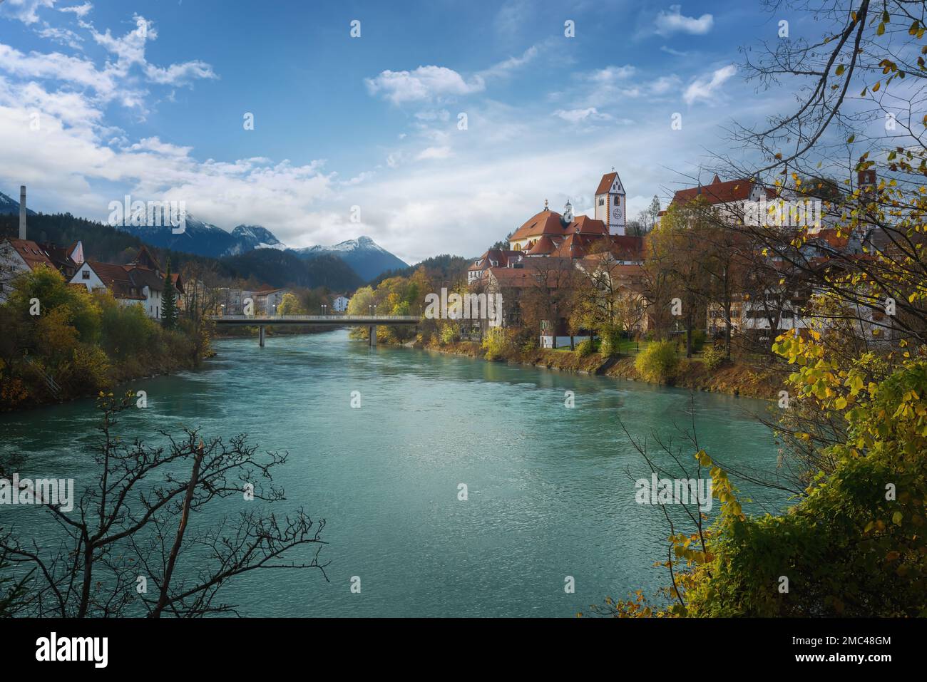 Fussen Skyline with Lech River, St. Mang Basilica and Allgau Alps - Fussen, Bavaria, Germany Stock Photo