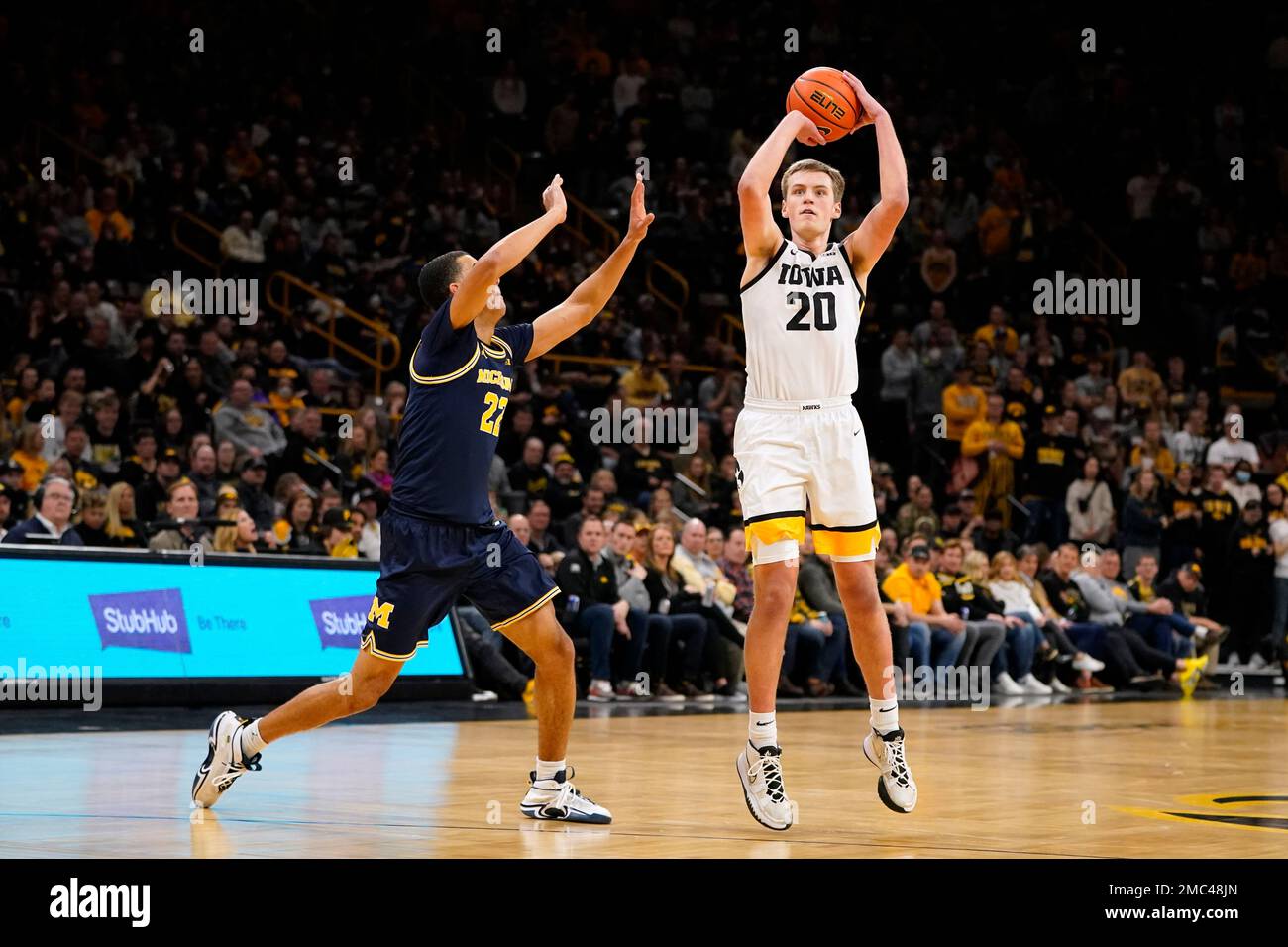 Iowa guard Payton Sandfort (20) shoots over Michigan forward Caleb