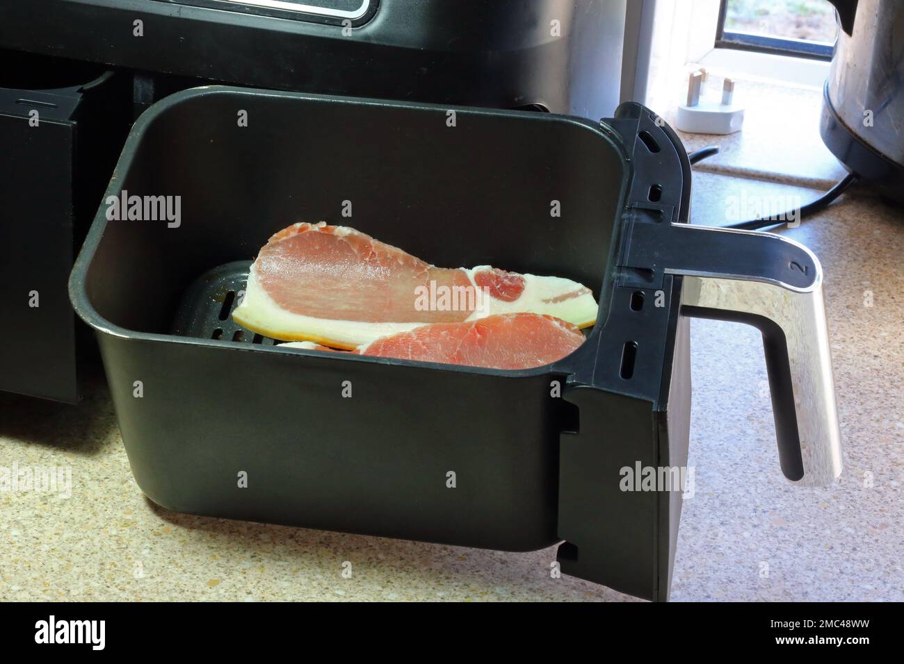 Air fryer drawer with raw pork bacon in ready to air fry Stock Photo Alamy