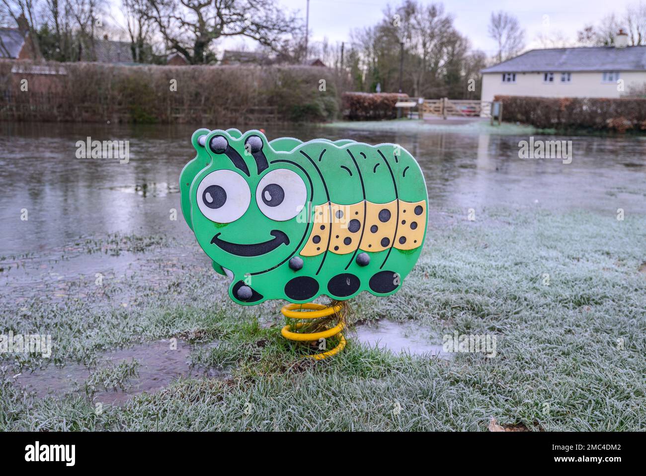 Caterpillar ride in a frozen flooded playground in winter, UK Stock ...