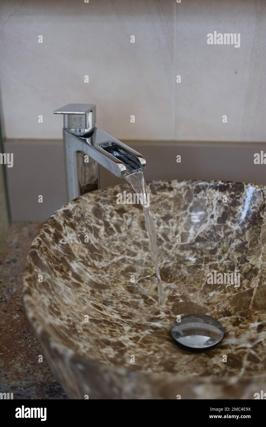 Water flows from the faucet in the bathroom, selective focus, shallow