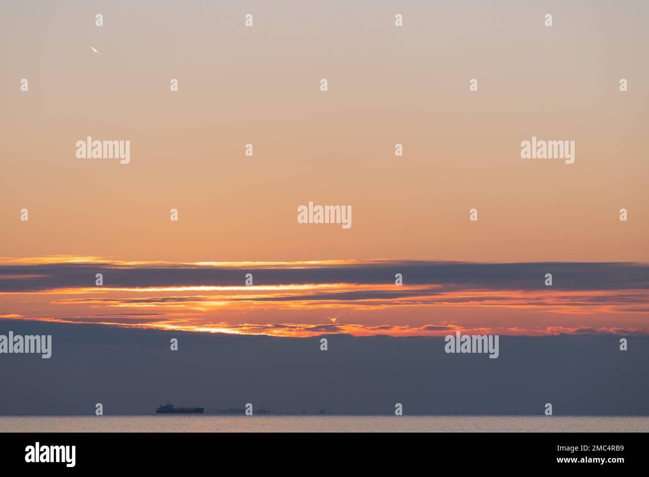 Beautiful sunrise on the sea with a ship Stock Photo - Alamy