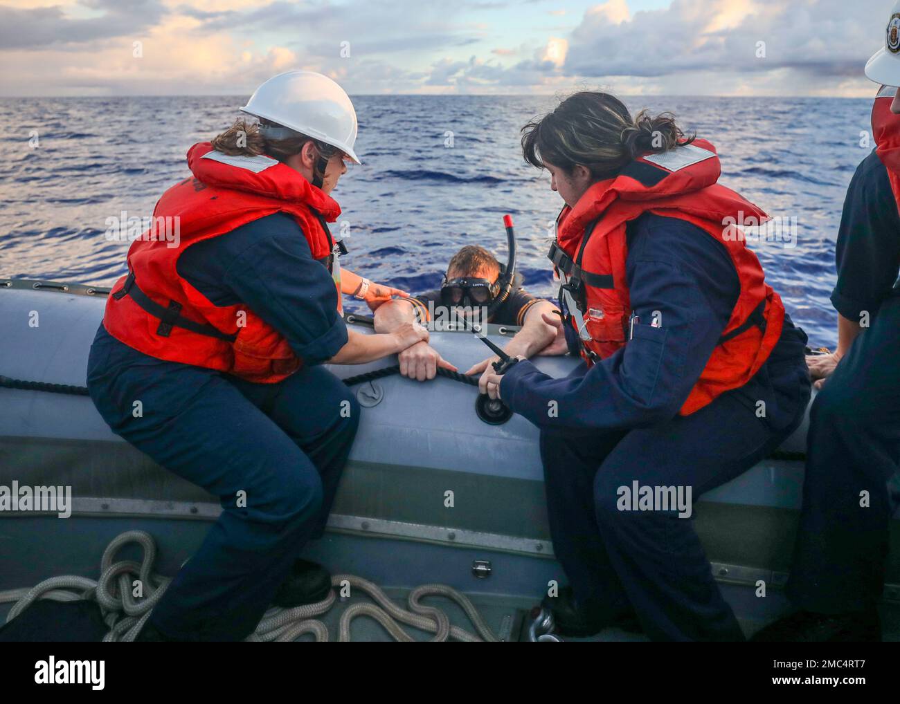 PHILIPPINE SEA (June 24, 2022) Gas Turbine Technician (Mechanical) 3rd Class Lucas Vath, center, from Minneapolis, enters a rigid-hull inflatable boat (RHIB) while Arleigh Burke-class guided-missile destroyer USS Benfold (DDG 65) conducts routine boat operations. Benfold is assigned to Commander, Task Force (CTF) 71/Destroyer Squadron (DESRON) 15, the Navy’s largest forward-deployed DESRON and the U.S. 7th Fleet’s principal surface force. Stock Photo