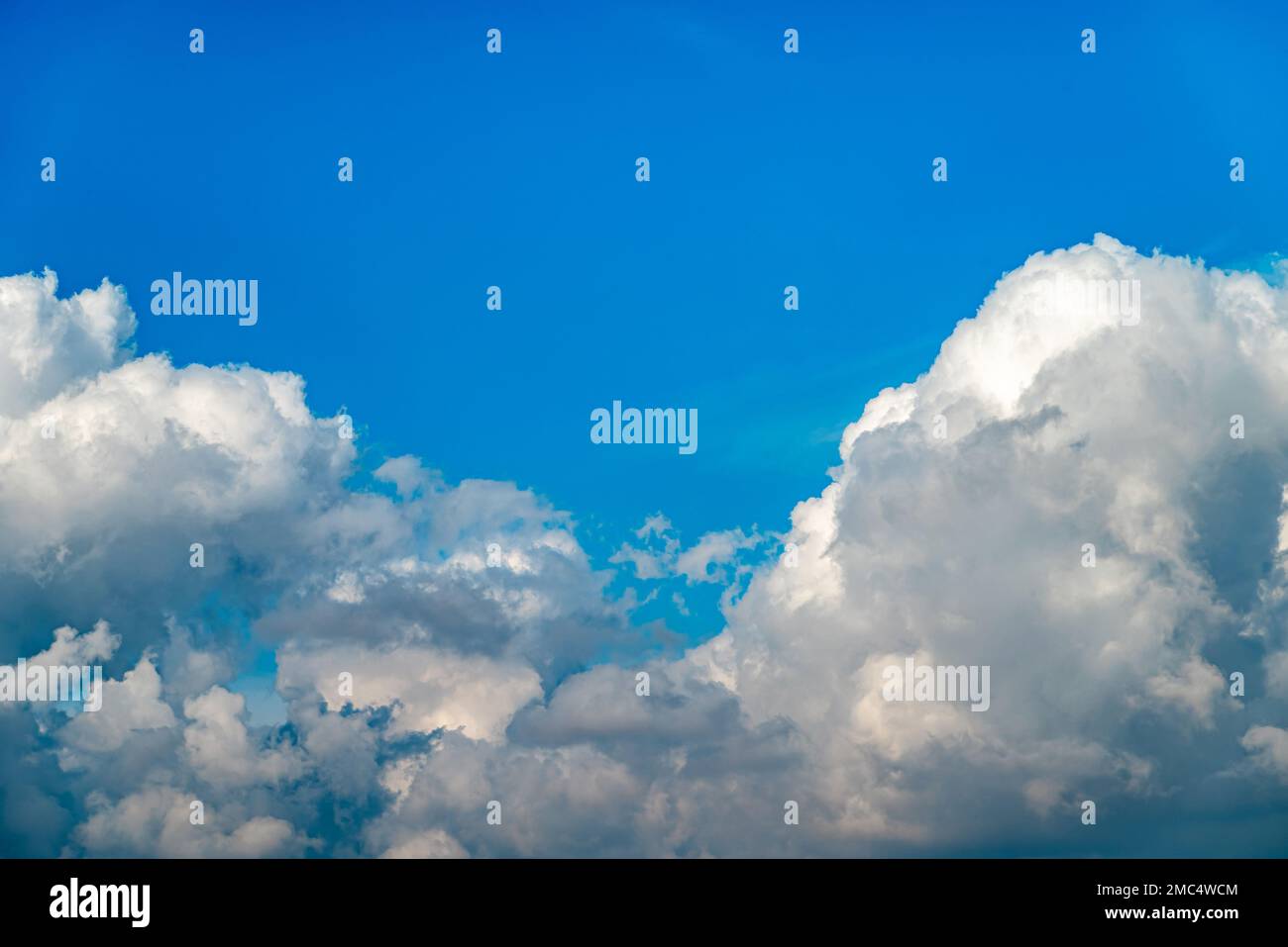 Dramatic image of bright blue sky with fluffy white clouds Stock Photo