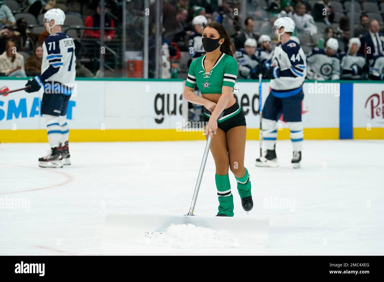 The Dallas Stars Ice Girls clean frost off the rink during an NHL
