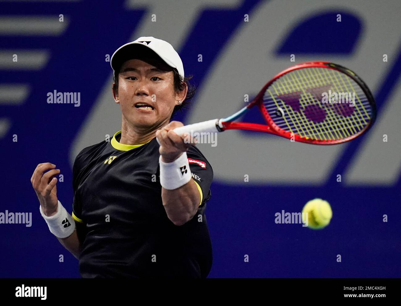 Yoshihito Nishioka, of Japan, hits a return to Taylor Fritz, of the United States, at the Mexican Open tennis tournament in Acapulco, Mexico, Wednesday, Feb