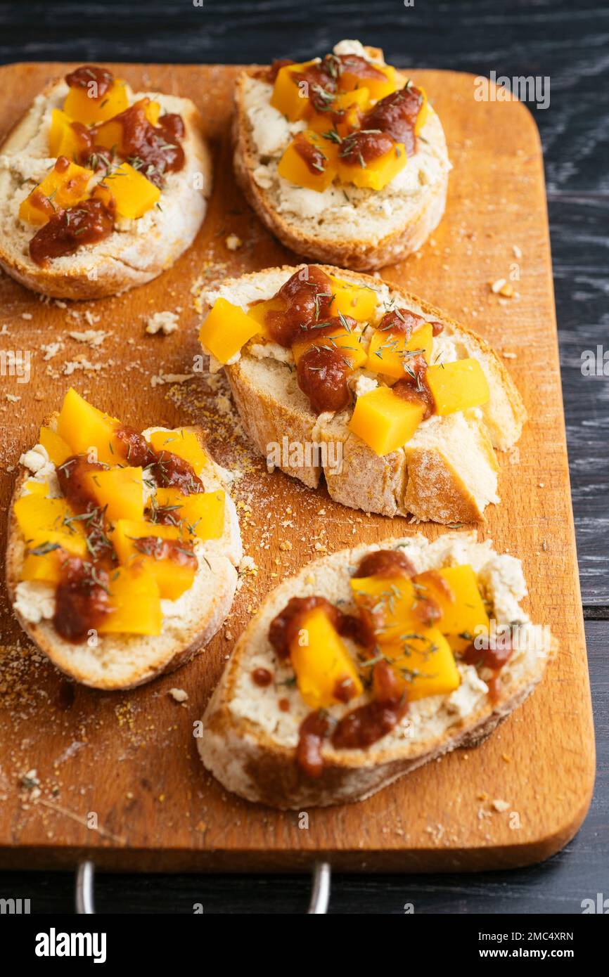 Bruschetta with vegan feta, winter squash and spicy plum sauce. Stock Photo