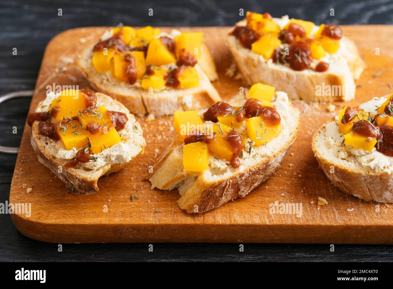 Bruschetta with vegan feta, winter squash and spicy plum sauce. Stock Photo