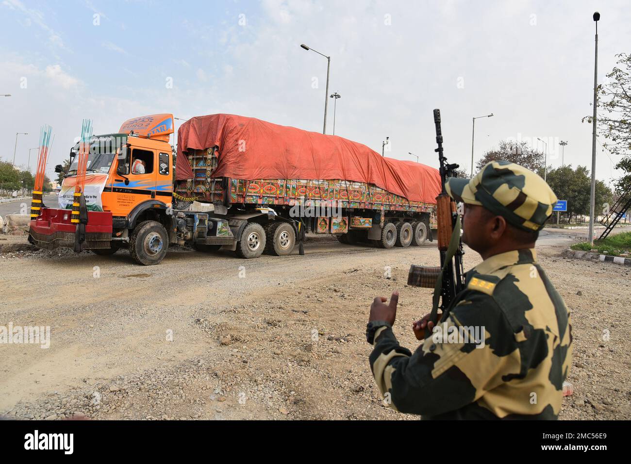 An Indian Border Security Force soldier guards as a truck carrying
