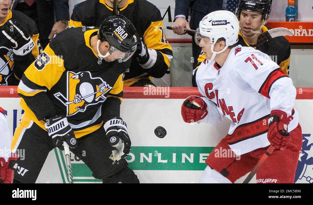 Pittsburgh Penguins defenseman Brian Dumoulin, (8), and Carolina Hurricanes winger Jesper Fast, (71), battle for a flying puck during the first period of an NHL hockey game on Sunday, Feb