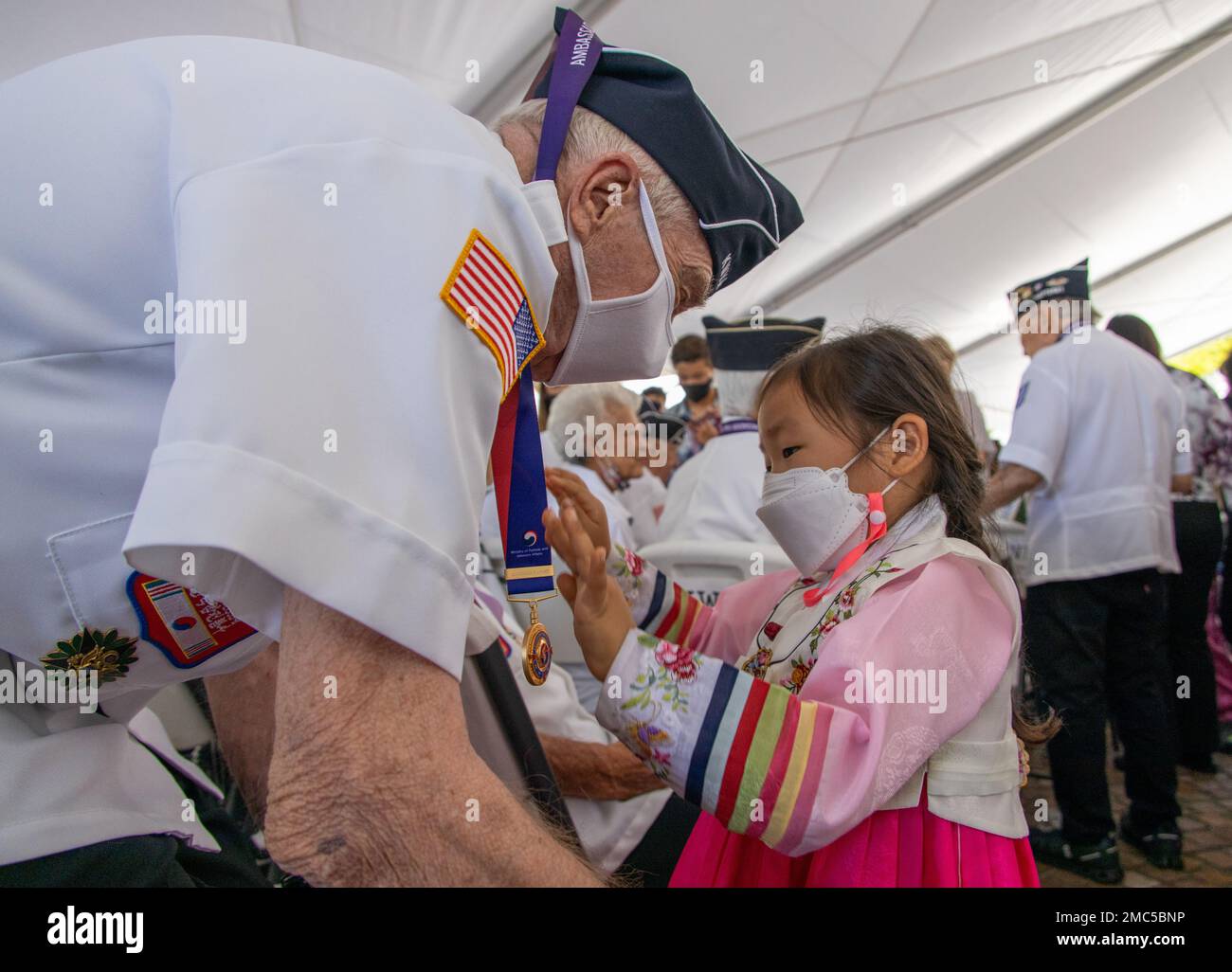 A child from the Korean community presents a medal to a Veteran with the Korean War Veterans Association during the 72nd Korean War Anniversary at the National Memorial Cemetery of the Pacific (Punchbowl) in Honolulu, Hawaii, June 25, 2022. The Korean War began on June 25, 1950, when North Korean armed forces invaded South Korea. The attack took place at several strategic points along the 38th parallel, the line dividing the communist Democratic People’s Republic of Korea from the Republic of Korea in the south. This event honors the lives lost and the sacrifices made during the war. Stock Photo