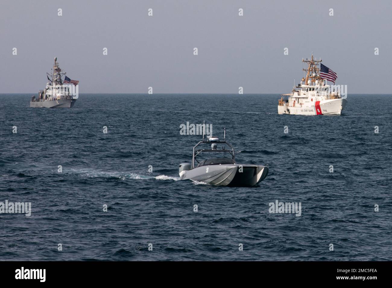 220626-A-JJ498-1224 ARABIAN GULF (June 26, 2022) A Devil Ray T-38 unmanned surface vessel, U.S. Coast Guard cutter USCGC Robert Goldman (WPC 1142), and coastal patrol ship USS Thunderbolt (PC 12) sail in the Arabian Gulf, June 26. U.S. naval forces regularly operate across the Middle East region to help ensure security and stability. Stock Photo