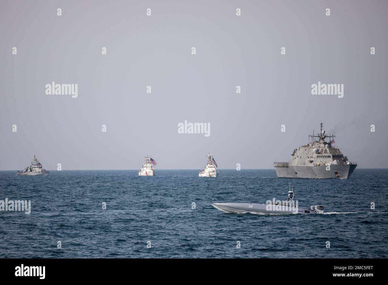 220626-A-JJ498-1220 ARABIAN GULF (June 26, 2022) A Devil Ray T-38 unmanned surface vessel, littoral combat ship USS Sioux City (LCS 11) and U.S. Coast Guard cutters USCGC Baranof (WPB 1318) and USCGC Robert Goldman (WPC 1142) and coastal patrol ship USS Thunderbolt (PC 12) sail in the Arabian Gulf, June 26. U.S. naval forces regularly operate across the Middle East region to help ensure security and stability. Stock Photo