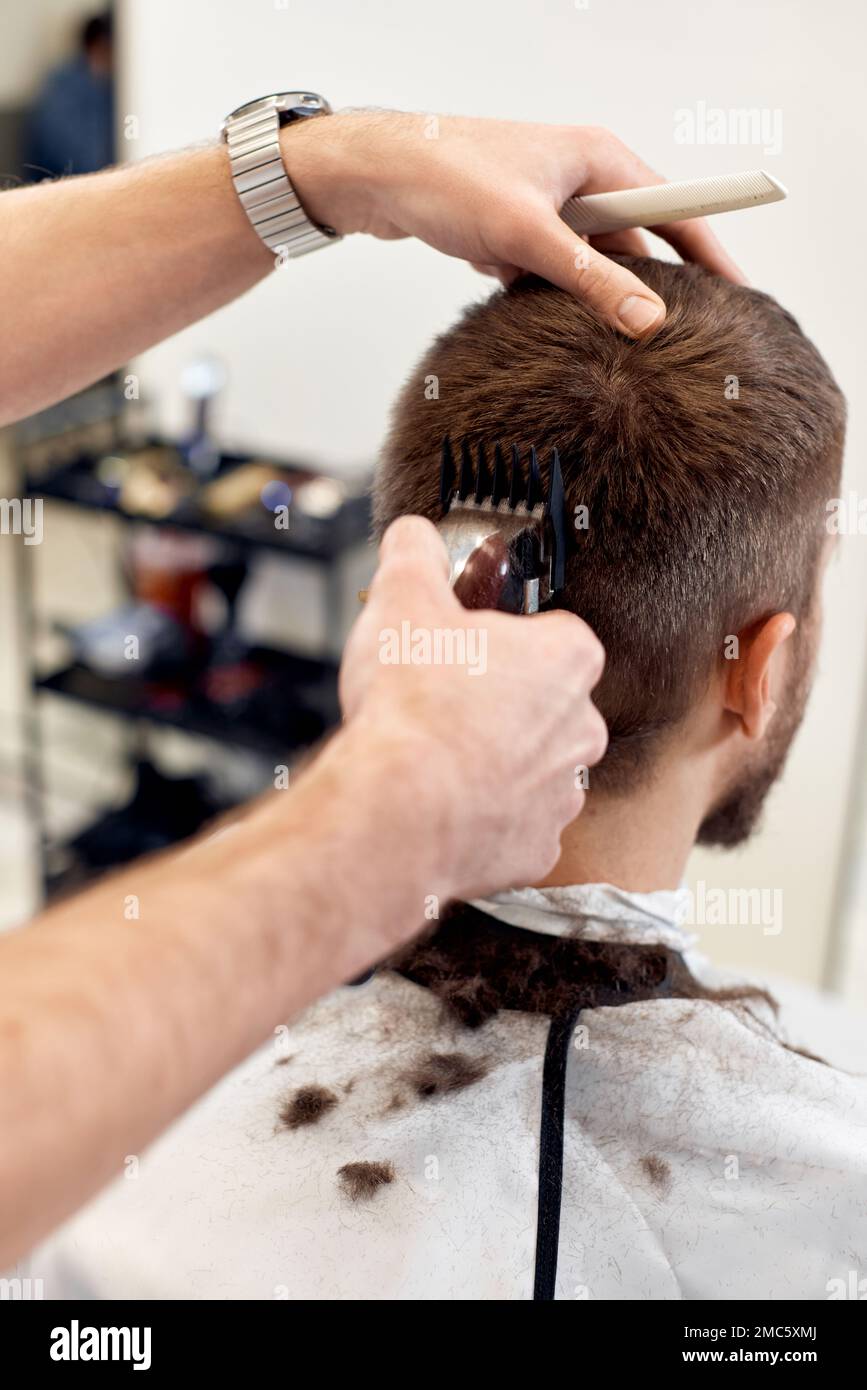 Barber trim hair with clipper on handsome bearded man Stock Photo - Alamy