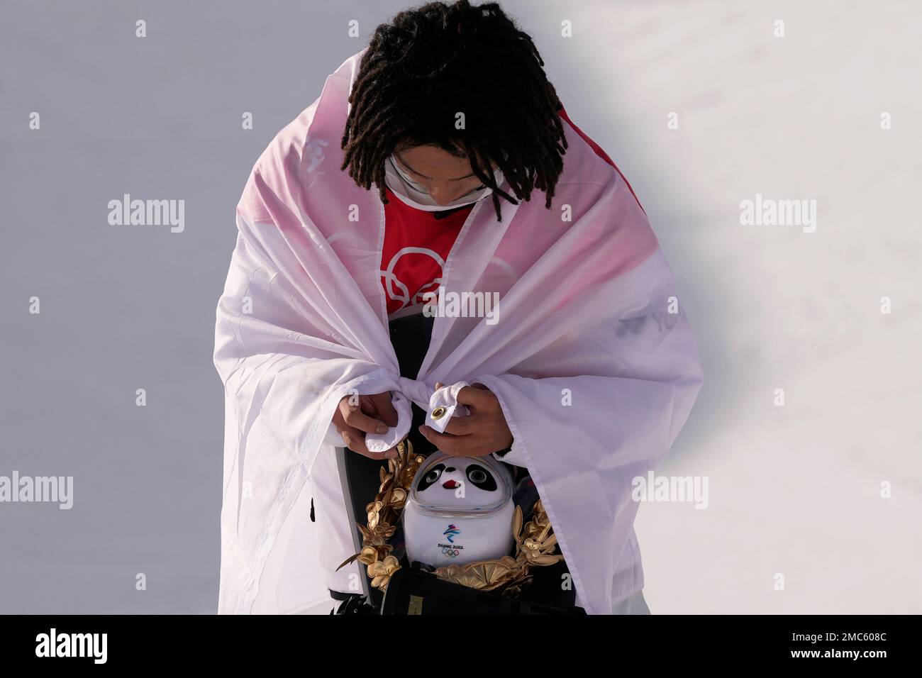 Gold medal winner Japan's Ayumu Hirano ties Japnes flag as he