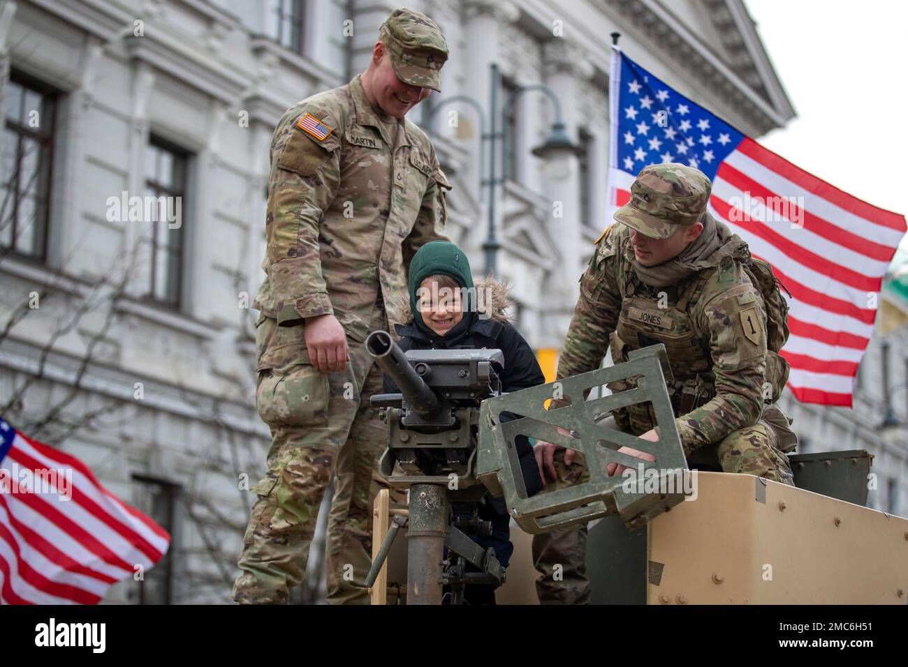 Members of the U.S. Army show a gun to a young boy on the armored vehicle  during the meeting with local residents at the Lukiskes square in Vilnius,  Lithuania, Wednesday, Feb. 16,