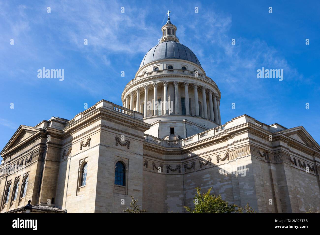 Pantheon building in Paris, France with focus on French flag over blue sky. Stock Photo