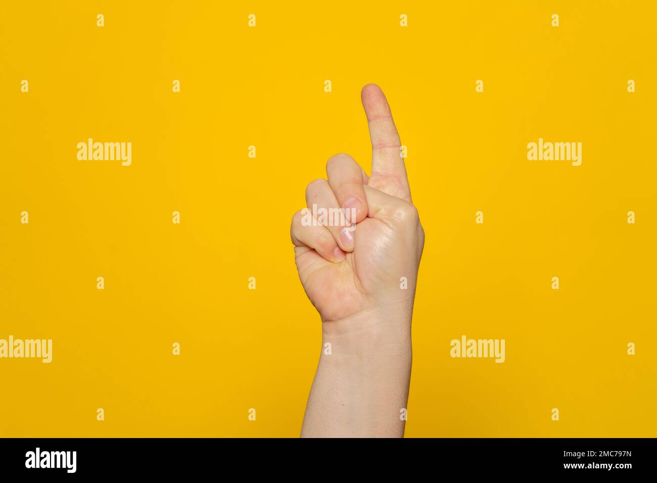 Hand shows index finger isolated on orange background, with clipping path, concept press the button first, double click the mouse, take the elevator. Stock Photo