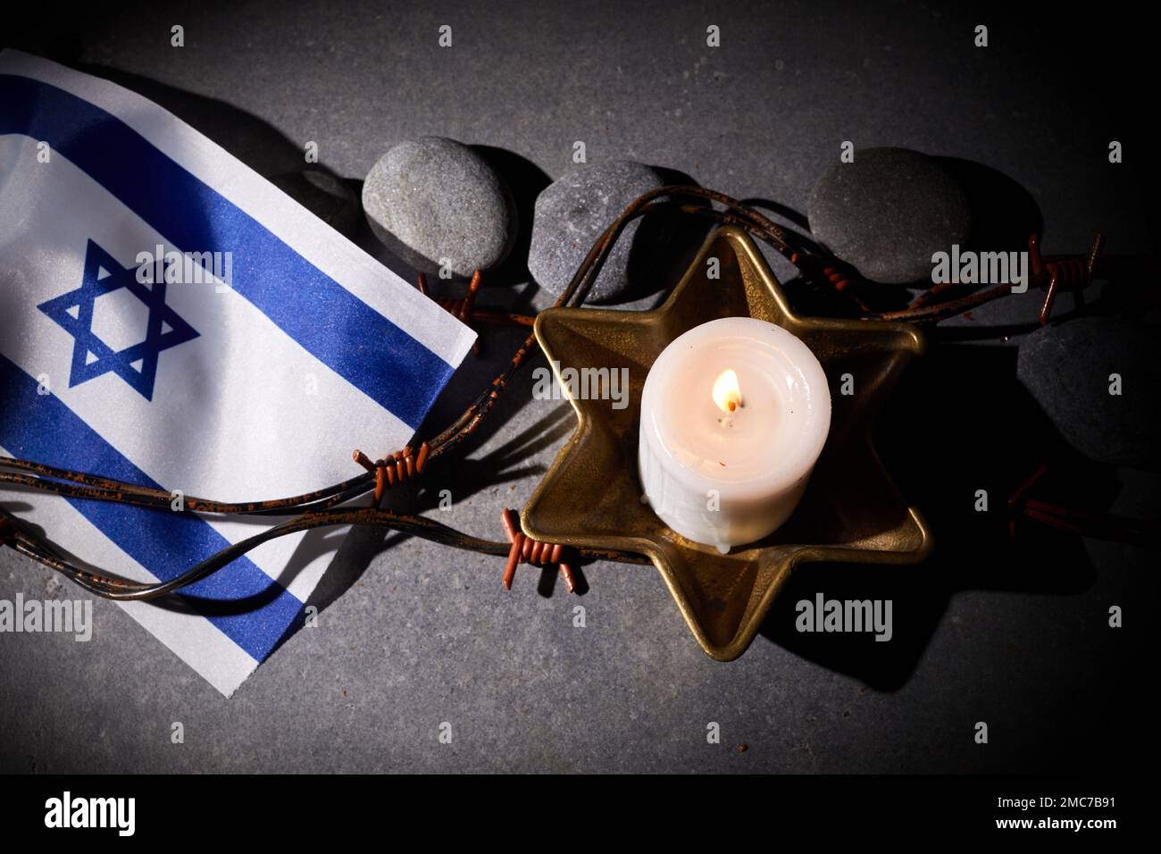 Burning candle, Barbed wire, flag of Israel on dark background