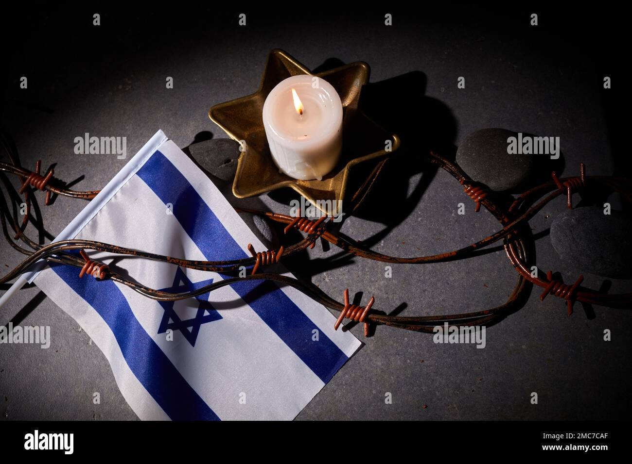 Burning candle, Barbed wire, flag of Israel on dark background
