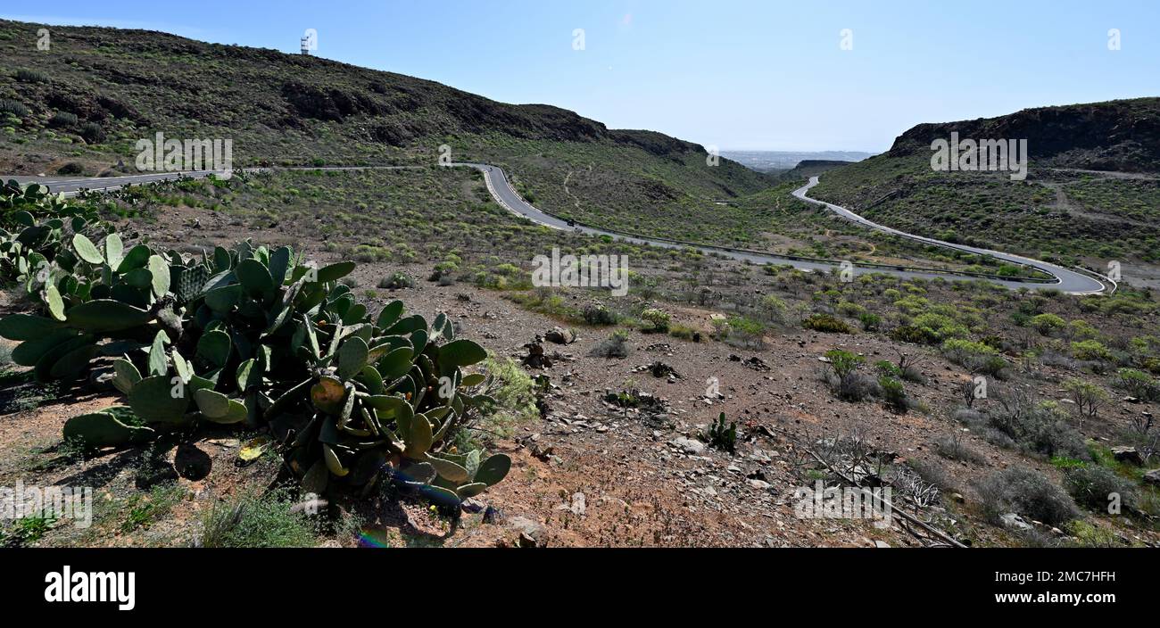Curving road on the lower slopes of mountains in of Bartolomé de Tirajana valley with view to coast, Gran Canaria Stock Photo