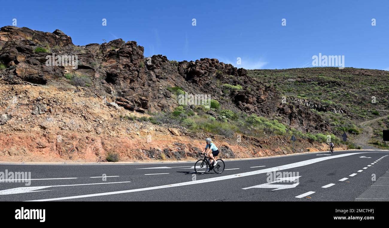 Cyclists on the way up mountain road of Bartolomé de Tirajana valley, Gran Canaria, Canary Islands Stock Photo