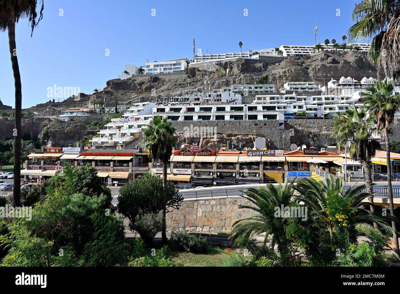 Tourist hotel complexes and shopping area on hillside in town of  Arguineguín, Gran Canaria Stock Photo