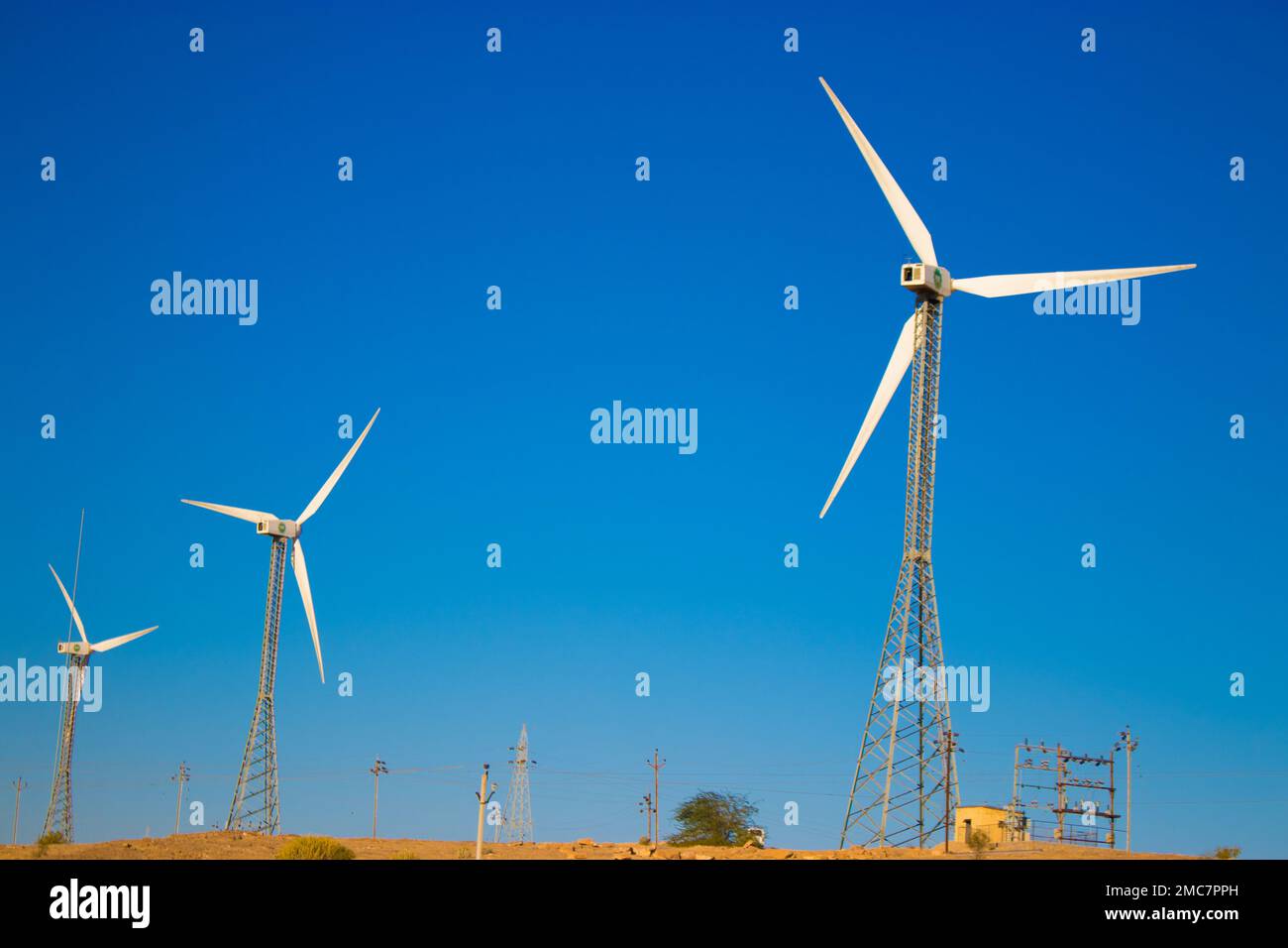 The windmills standing on a field with withered grass under the clear, blue sky Stock Photo Alamy