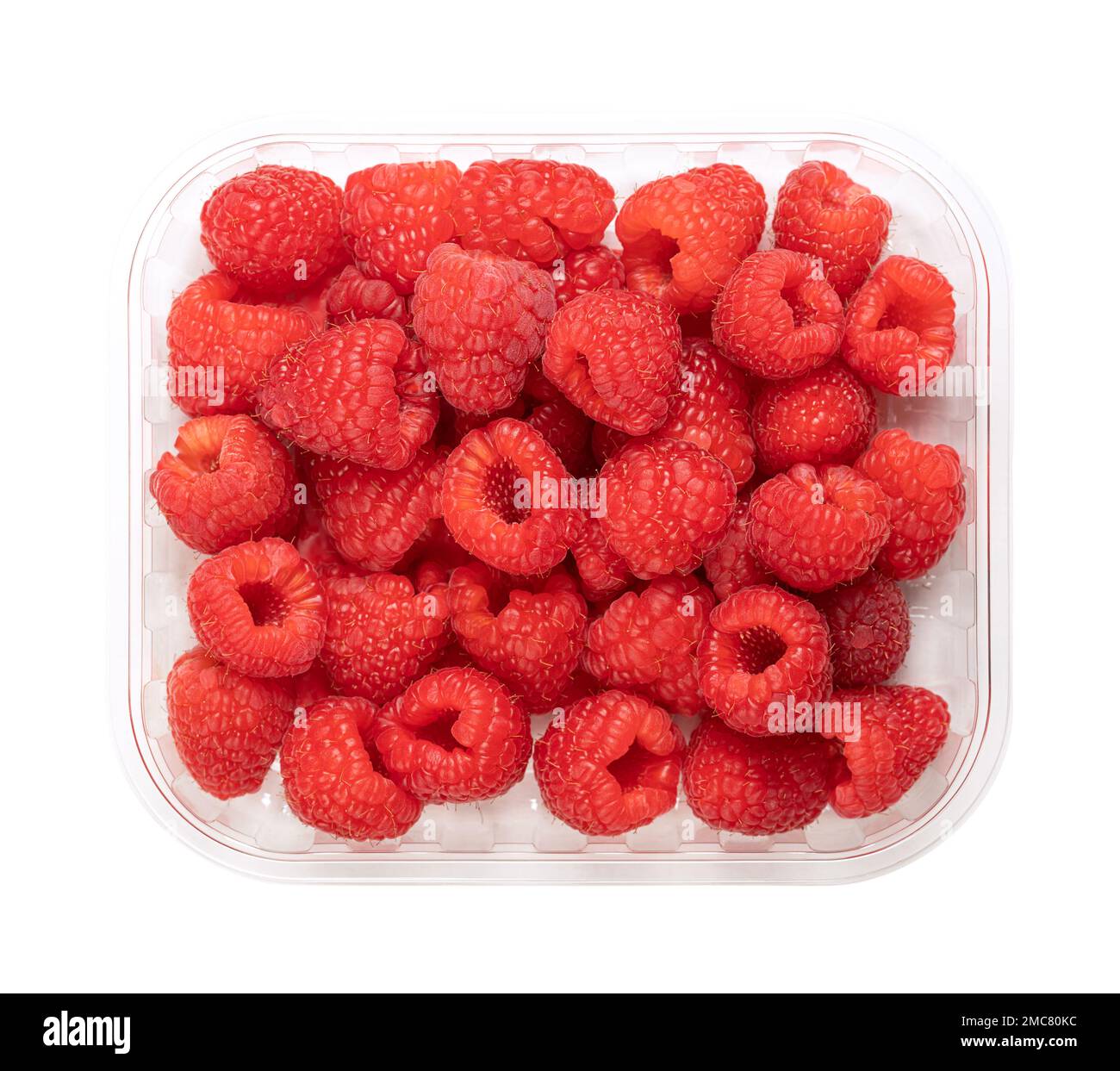 Whole fresh raspberries, in a clear plastic punnet, from above. Ripe, red and sweet fruits of Rubus idaeus, the cultivated European raspberry. Stock Photo