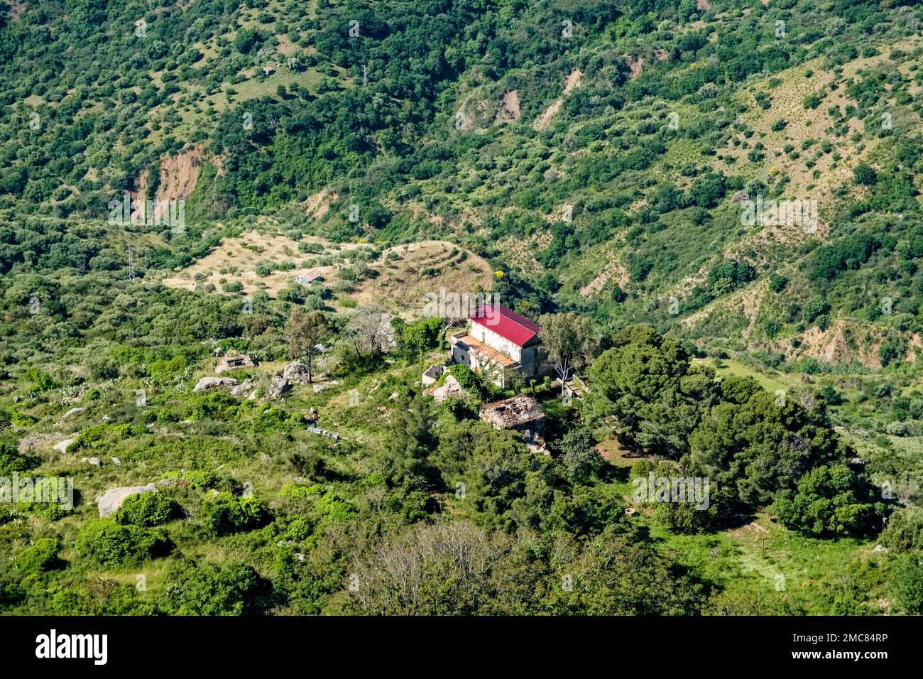 Sicilian agricultural landscape with a lonely farmhouse below the small town of Pollina. Stock Photo
